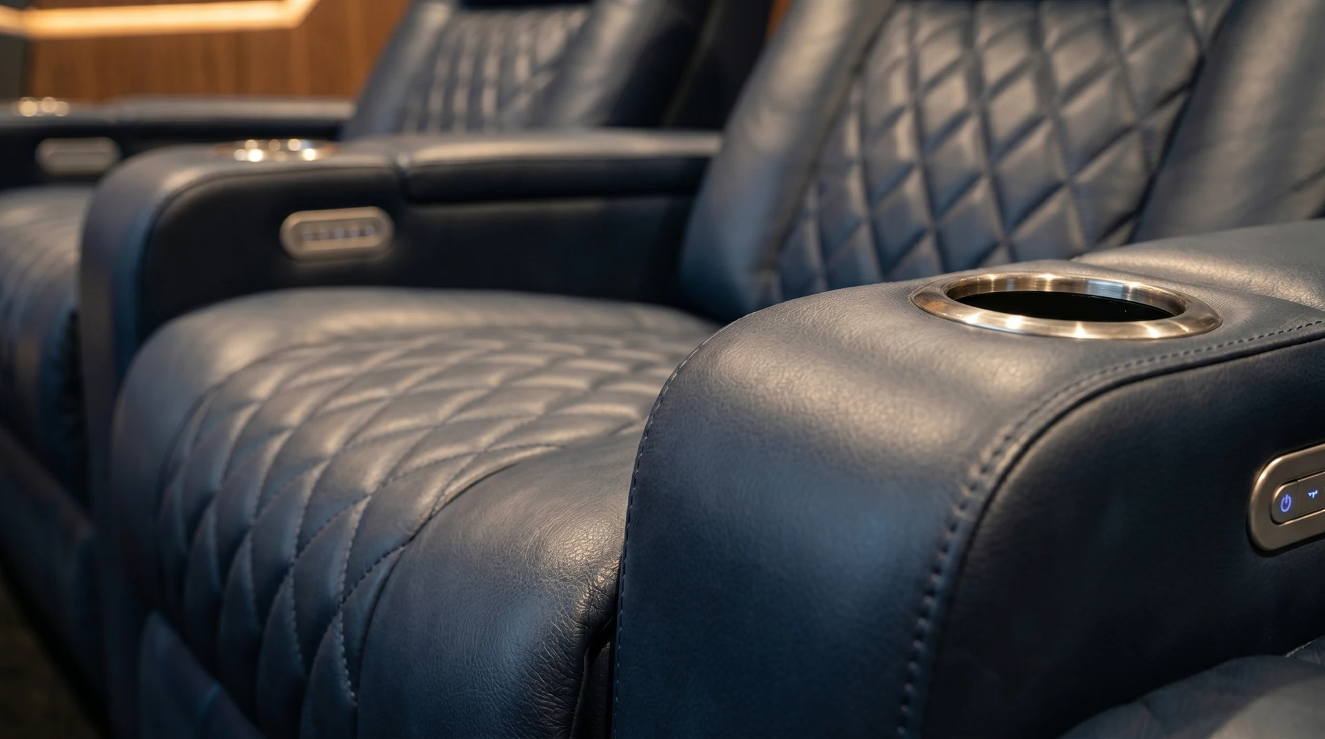 Pelle, cuciture e portabicchiere nel dettaglio della poltrona cinema.