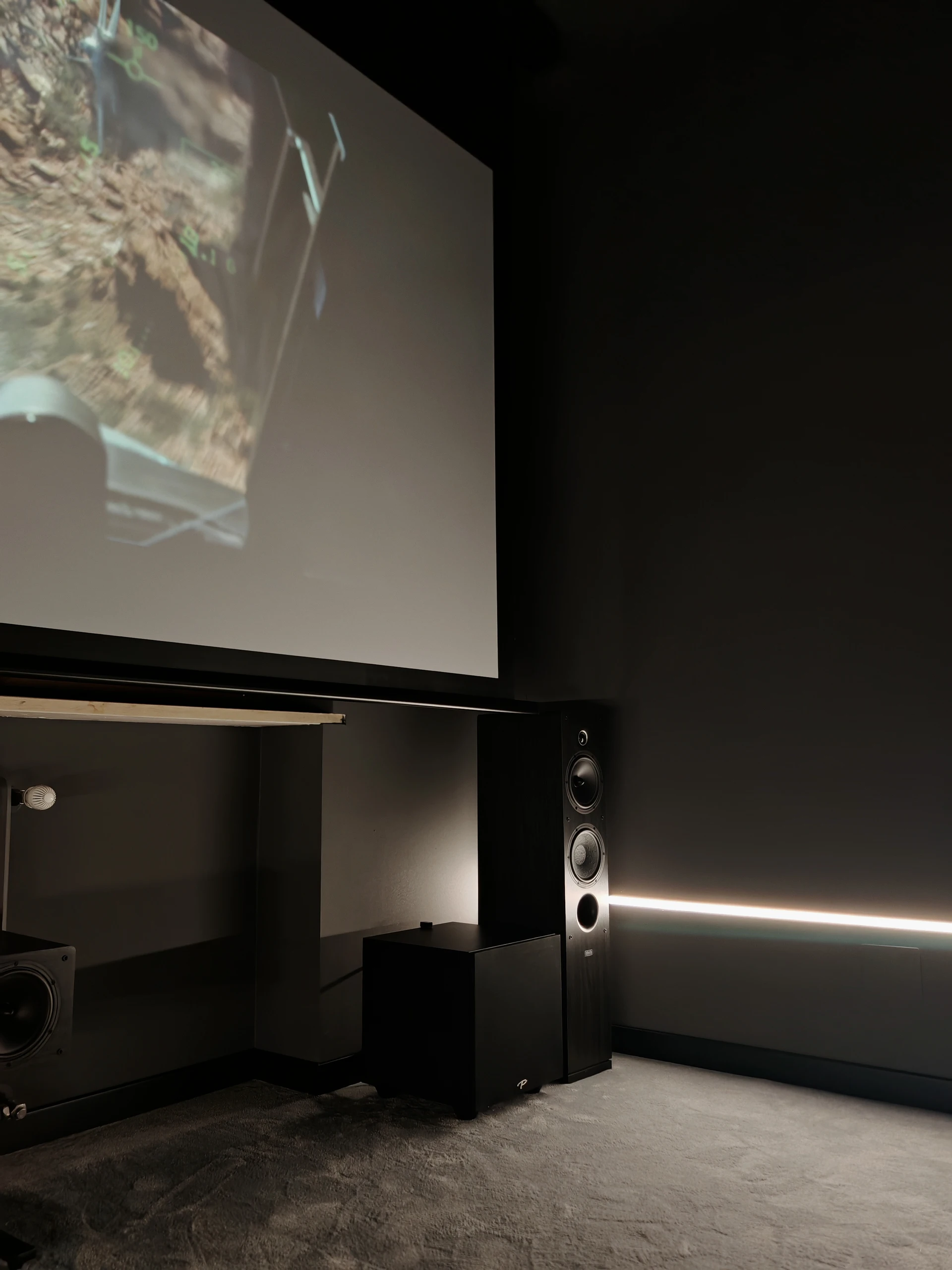 Dettaglio del fronte cinema di Volpiano con diffusore a torre, subwoofer e bordo dello schermo.
