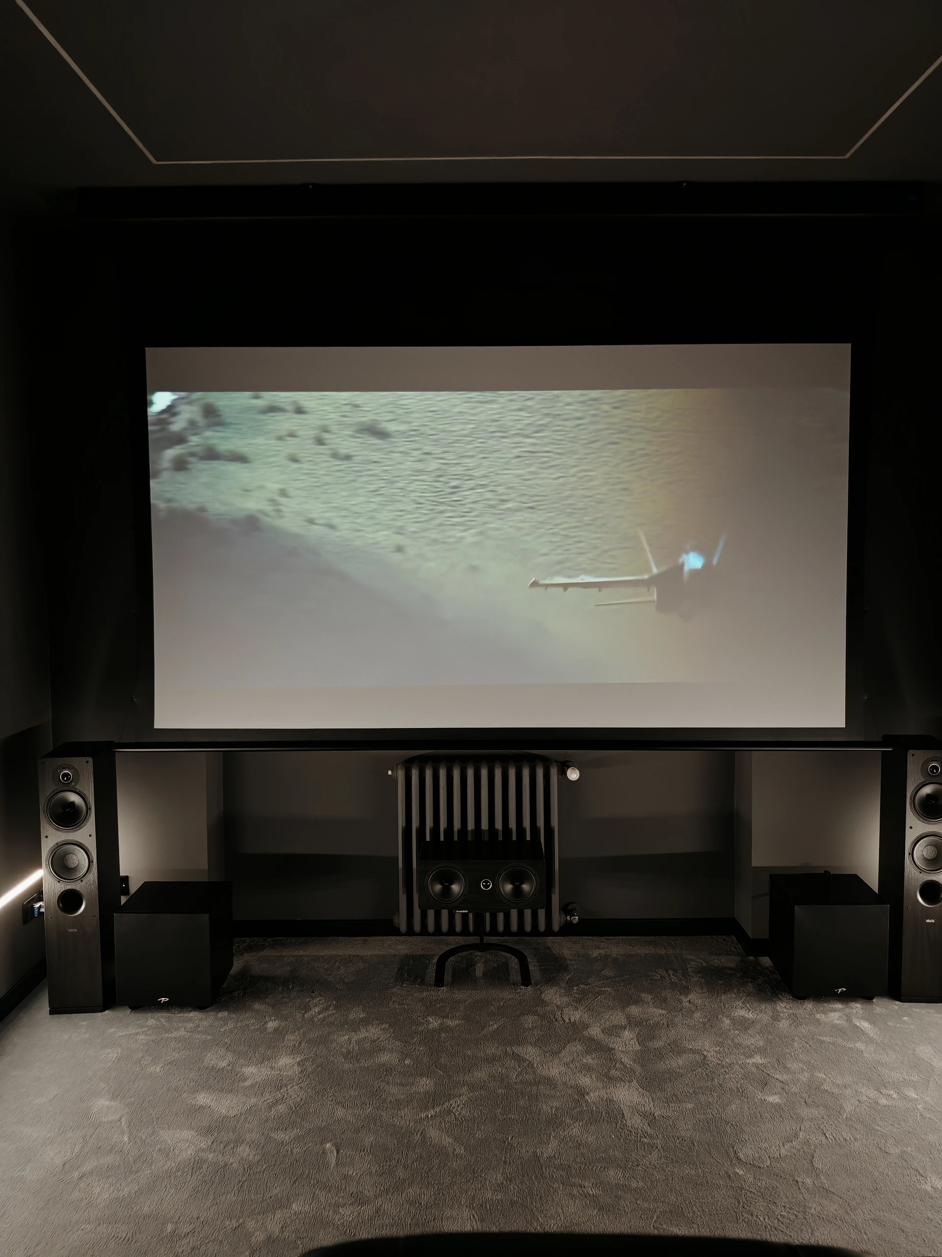 Sala di Volpiano vista frontalmente, con schermo in proiezione e sistema audio sotto l’immagine.
