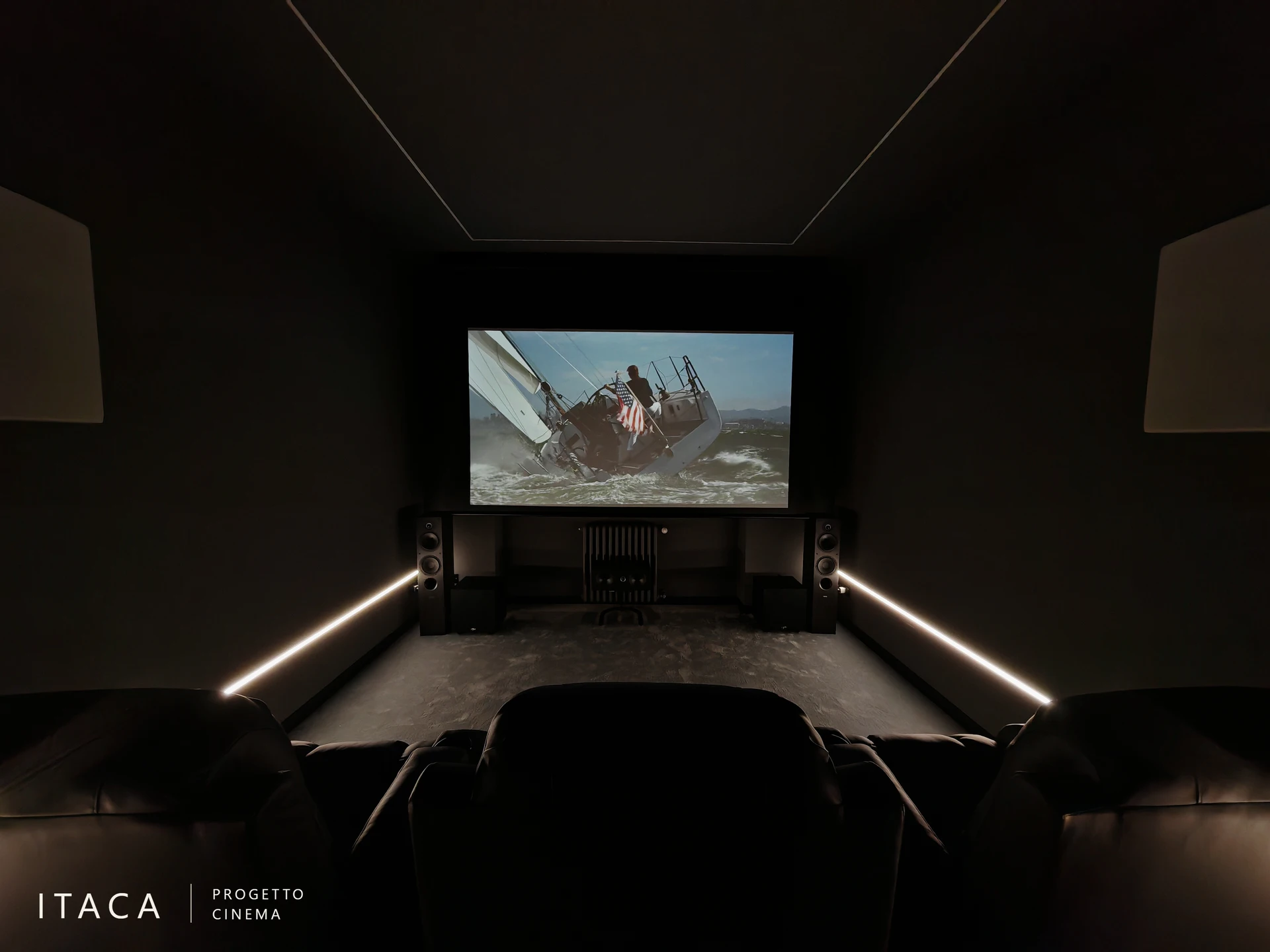 Sala cinema di Volpiano vista dalle sedute, con proiezione attiva e strip LED lungo le pareti.
